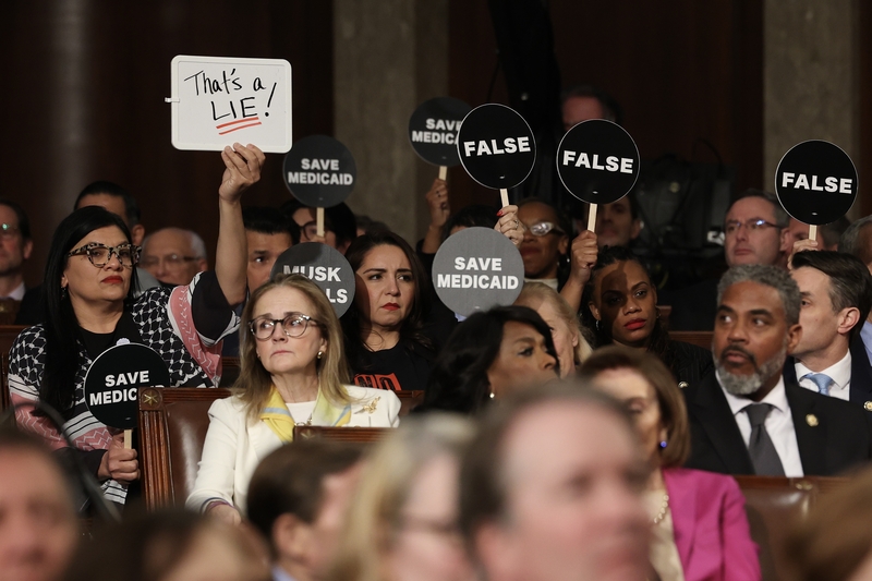 Democrats hold protest signs as U.S. President Donald Trump address a joint session of Congress at the U.S. Capitol on March 4, 2025, in Washington, D.C. (Photo by Win McNamee/Getty Images)