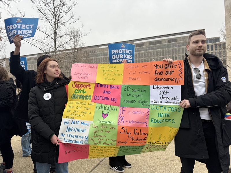From left, Olivia Sawyer and Jeremy Bauer-Wolf protest the U.S. Education Department’s mass layoffs during a "honk-a-thon" and rally March 14, 2025, in Washington, D.C. (Photo by Shauneen Miranda/States Newsroom)