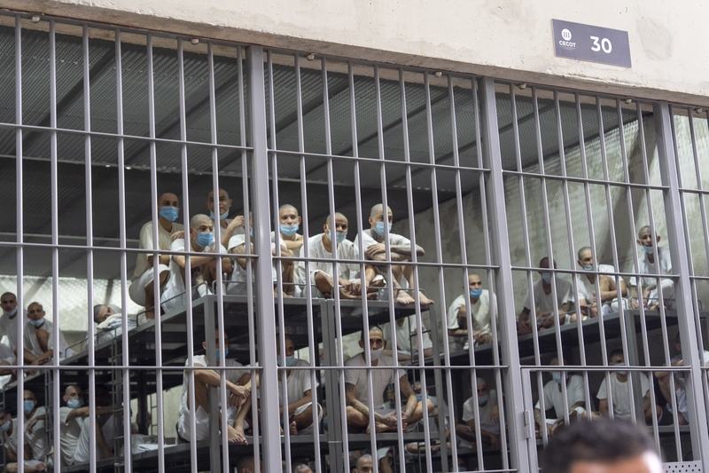 Prisoners look out of their cell as Department of Homeland Security Secretary Kristi Noem tours the Terrorist Confinement Center, or CECOT, on March 26, 2025 in Tecoluca, El Salvador. (Photo by Alex Brandon-Pool/Getty Images)