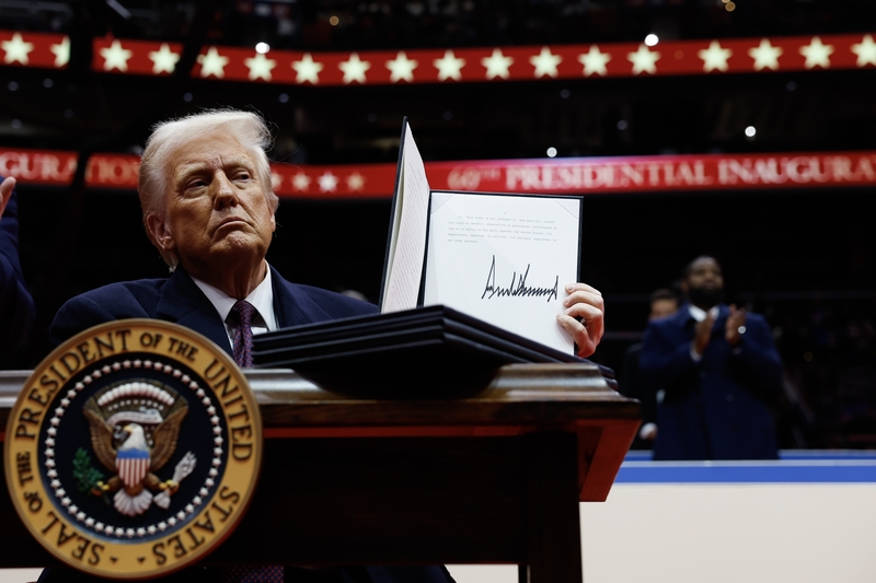President Donald Trump holds up an executive order after signing it during an indoor inauguration parade at the Capital One Arena on Jan. 20, 2025 in Washington, D.C.  (Photo by Anna Moneymaker/Getty Images)