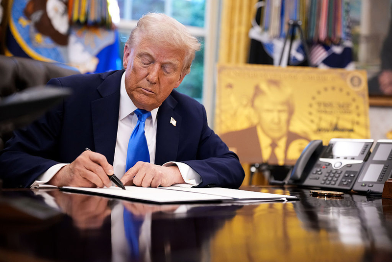 President Donald Trump signs an executive order on September 19, 2025, introducing a $100,000 fee for H-1B visas that allows foreign nationals permanent residency and a pathway to U.S. citizenship.  (Photo by Andrew Harnik/Getty Images)