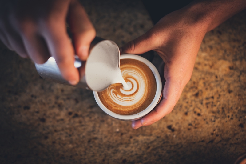 Close up of the human hand making coffee.