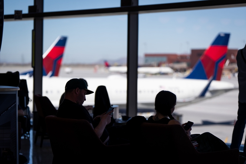 People sit in front of windows looking out on the tarmac at Salt Lake City International Airport in Salt Lake City on April 3, 2024. (Photo by Spenser Heaps for Utah News Dispatch)