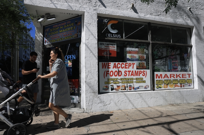 A 'We Accept (Food Stamps)' sign hangs in the window of a grocery store on Oct. 31, 2025 in Miami, Florida.  (Photo by Joe Raedle/Getty Images)