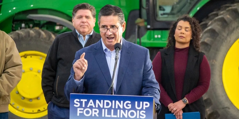 Jerry Costello II, director of the Illinois Department of Agriculture, speaks at a Christian County farm alongside Gov. JB Pritzker (left) and Cameron Joost, assistant director of the Illinois Department of Commerce and Economic Opportunity. The group discussed the impact of tariffs on Illinois farmers in an October visit. (Capitol News Illinois photo by Jerry Nowicki)