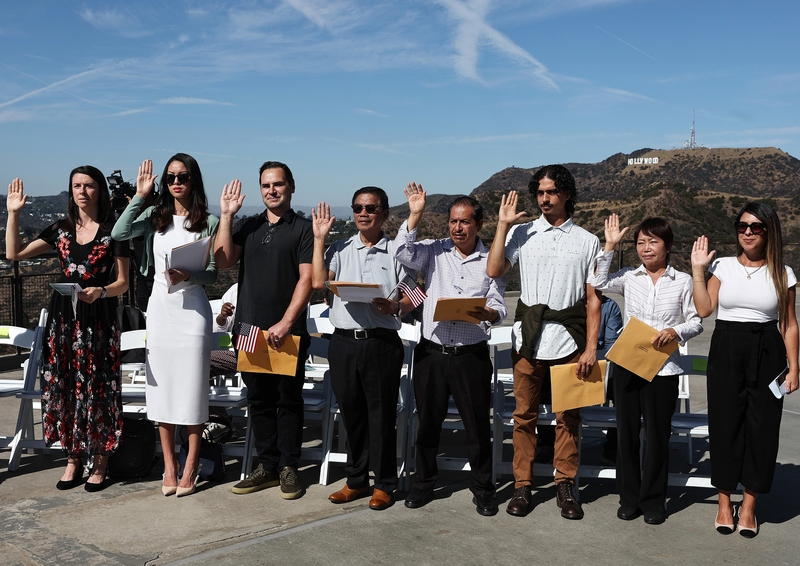 People are sworn in as new U.S. citizens during a special U.S. Citizenship and Immigration Services naturalization ceremony on the Hollywood Sign Terrace at historic Griffith Observatory on Oct. 21, 2024 in Los Angeles. (Photo by Mario Tama/Getty Images)