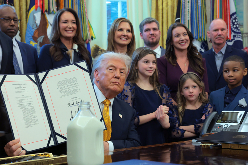 President Donald Trump displays a signed bill during an event with dairy farmers in the Oval Office of the White House on January 14, 2026 in Washington, DC. Trump signed a series of bills including the "Whole Milk for Healthy Kids Act" to allow the sale of whole milk in school cafeterias across the country. (Photo by Anna Moneymaker/Getty Images)
