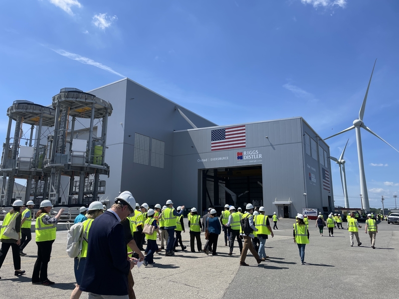Officials with Orsted, Riggs Distler, Eversource and the state of Rhode Island lead a tour of ProvPort, where major components of the Revolution Wind project were being assembled, in Providence in 2024. The 700-megawatt offshore wind project, which is largely complete, has been battling the Trump administration in court over stop-work orders. (Robert Zullo/ States Newsroom)