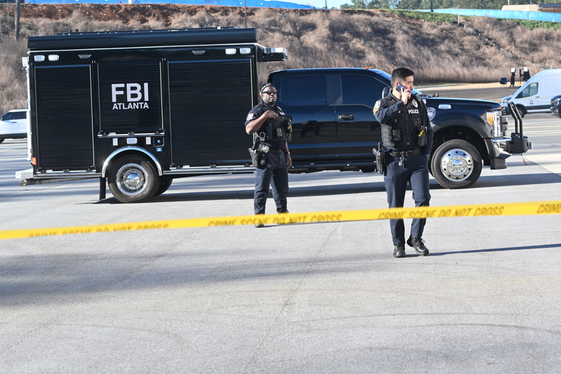 Fulton County Police officers stand by outside county election headquarters while FBI agents seize documents related to the 2020 election.