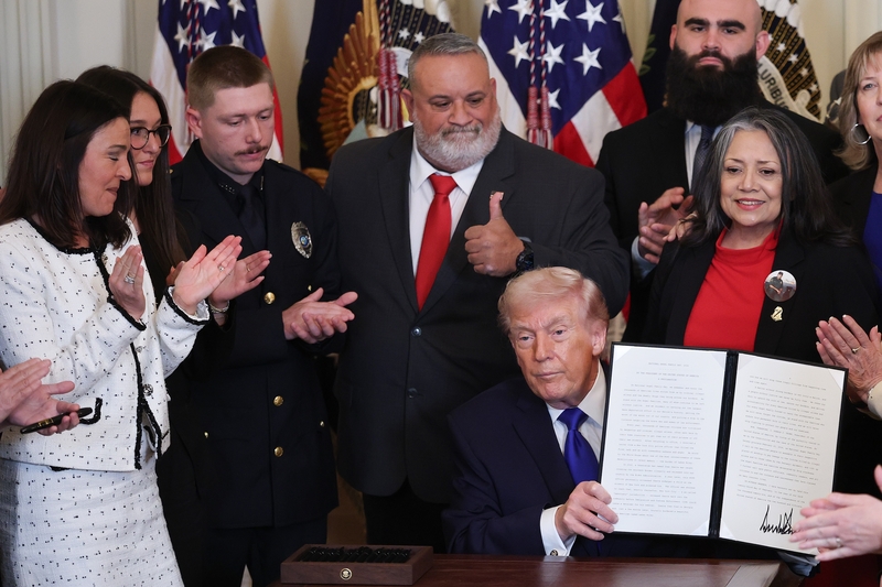 resident Donald Trump, surrounded by family members who have lost a relative to a crime committed by an undocumented immigrant, holds up a proclamation dedicating February 22nd as Angel Family Day during a remembrance ceremony held in the East Room at the White House February 23, 2026 in Washington, DC. The term “Angel Families” is used to describe people who have lost a relative to a crime committed by an undocumented immigrant. (Photo by Win McNamee/Getty Images)