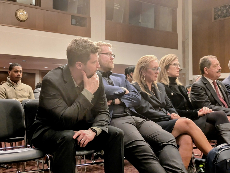 Brent Ganger, far left, and Luke Ganger, second from left, brothers of Renee Good, watch a forum on Department of Homeland Security use of force organized by congressional Democrats on Feb. 3, 2026. Good was killed by a federal immigration officer Jan. 7. (Photo by Ashley Murray/States Newsroom)