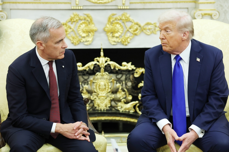 President Donald Trump, right, and Canadian Prime Minister Mark Carney speak to reporters in the Oval Office of the White House on Oct. 7, 2025 in Washington, D.C.  (Photo by Anna Moneymaker/Getty Images)