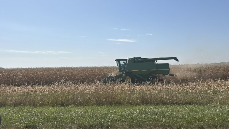 A farmer harvests corn beside Iowa Highway 163. (Photo by Cami Koons/Iowa Capital Dispatch)