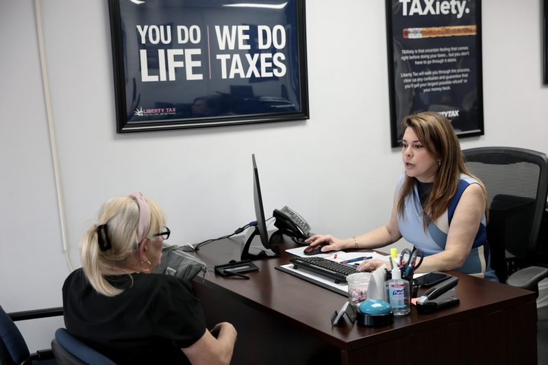 Maritza Montejo, a Liberty Tax Service office manager, helps Aurora Hernandez, left, with her taxes at a Liberty Tax Service office on the last day to file taxes on April 15, 2026, in Miami, Florida. (Photo by Joe Raedle/Getty Images)