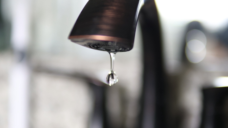 Close-up photo of water dripping out of a faucet