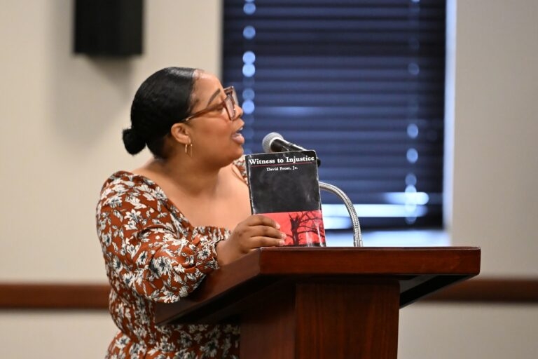 Eliza Jane Franklin of Barbour County holds up a copy of “Witness to Injustice,” a book by David Frost Jr. about racial violence and the Civil Rights Movement in Eufala, Alabama while speaking to the House Ways and Means General Fund Committee on May 5, 2026 at the Alabama Statehouse in Montgomery, Alabama. Franklin spoke in opposition to a bill that would set new primary dates should the U.S. Supreme Court allow the state to use maps ruled racially discriminatory in the past. (Brian Lyman/Alabama Reflector