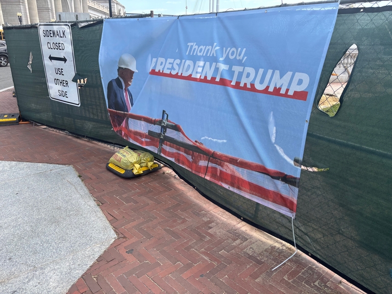 A sign praising President Donald Trump hangs on a construction site outside Union Station in Washington, D.C. (Photo by David Lightman/States Newsroom)
