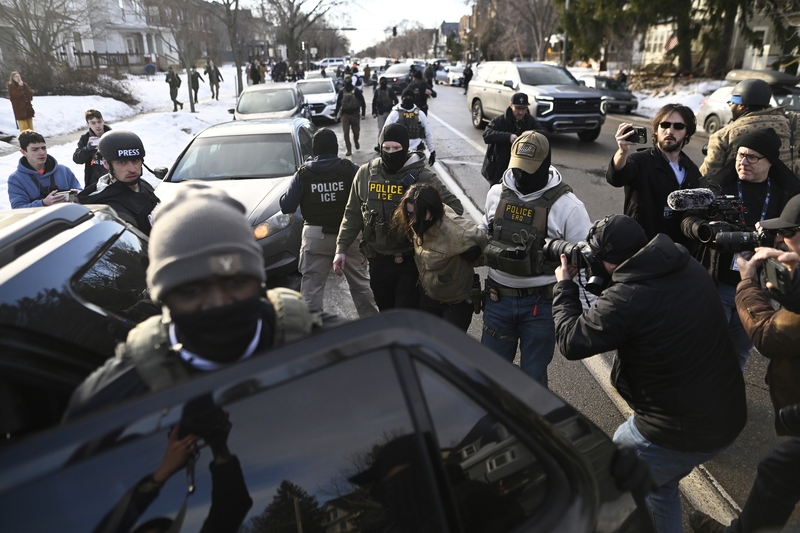 An observer is detained by ICE agents after they arrested two people from a residence on Jan. 13, 2026 in Minneapolis, Minnesota. (Photo by Stephen Maturen/Getty Images)