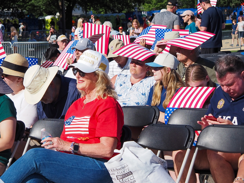 People in the crowd shaded themselves with American flag placards as they waited for President Donald Trump's speech at the Freedom 250 kick-off rally in Washington, D.C., on Wednesday, June 24, 2026. (Photo by Ashley Murray/States Newsroom)