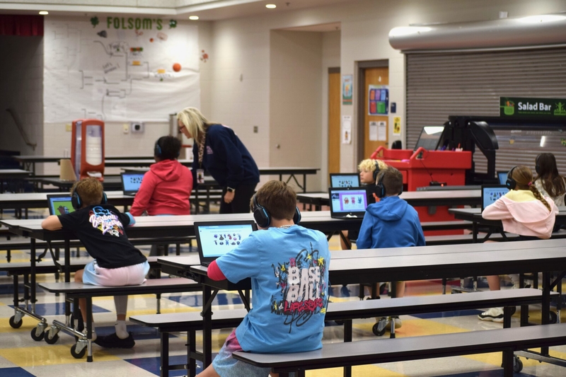 Students sit in a lunchroom in Arkansas on laptops