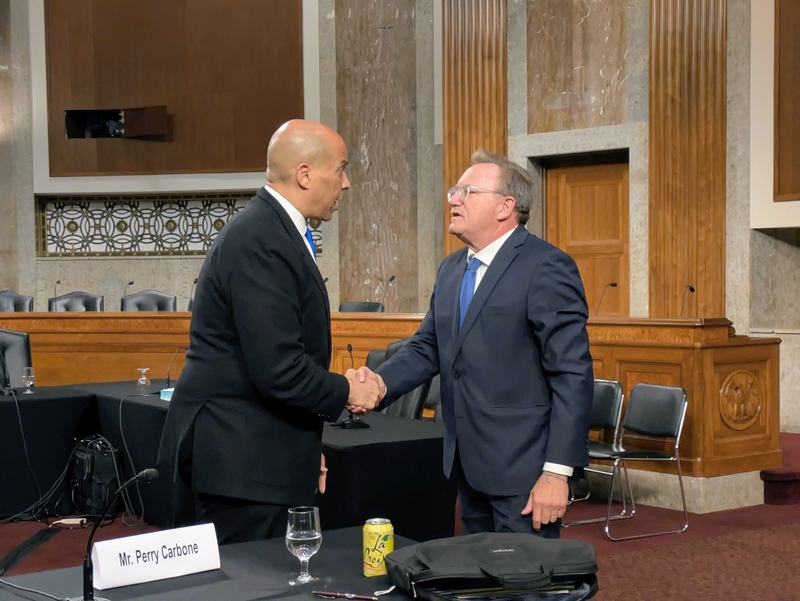Sen. Cory Booker, D-N.J., left, shook hands with former Department of Justice prosecutor Perry Carbone following a forum about the nomination of acting Attorney General Todd Blanche at the Dirksen Senate Office Building on Wednesday, July 22, 2026. (Photo by Ashley Murray/States Newsroom)