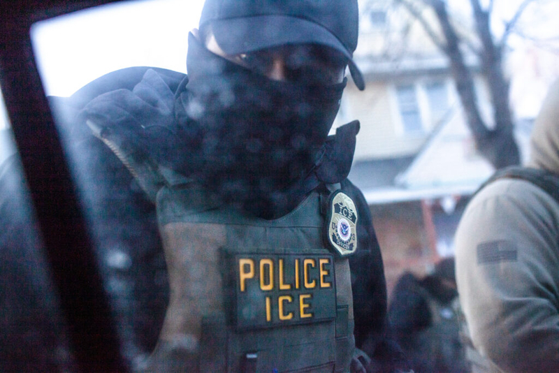 A masked U.S. Immigration and Customs Enforcement agent knocks on a car window in Minnesota on Jan. 12. (Photo by Nicole Neri/Minnesota Reformer)
