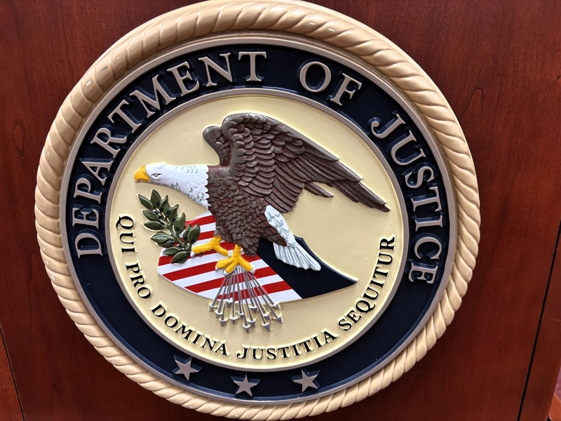 The U.S. Department of Justice logo is displayed on a speaker’s podium at the federal courthouse in Rapid City, South Dakota, on July 21, 2026. (Photo by Seth Tupper/South Dakota Searchlight)