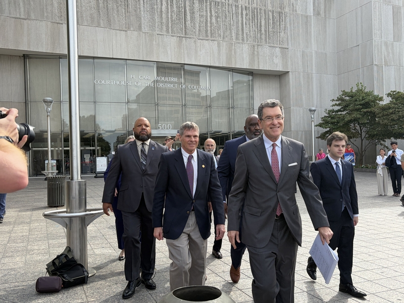 Olympian David Hearn, center left, walks out of District of Columbia Superior Court with his attorneys after a hearing on Sept. 4, 2026. (Photo by Ariana Figueora/States Newsroom)