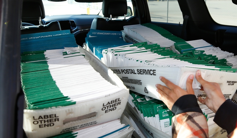 A Utah County election worker picks up mailed ballots from the United States Postal Service office on Oct. 26, 2020 in Provo, Utah. (Photo by George Frey/Getty Images)