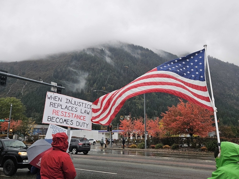 Alaskans braved the rain and wind to rally for No Kings and urge early voting in Juneau. (Photo by Corinne Smith/Alaska Beacon)