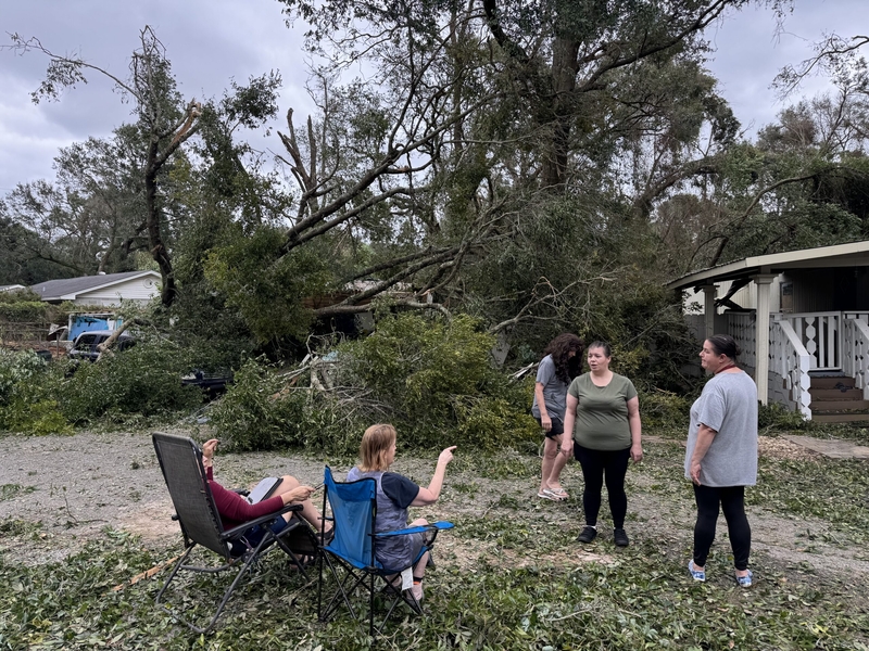 Cher Stanturf, her daughters and neighbors touch base on Oct. 10, 2026, the morning after Hurricane Isaias ripped through their mobile home park in Pensacola, Florida.