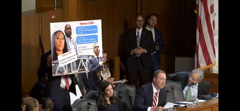 Sen. Eric Schmitt, R-Mo., speaks during a U.S. Senate Judiciary Committee hearing while a poster is displayed purporting to show text messages between former special counsel Jack Smith and security personnel about his attendance at an Atlanta Hawks NBA game. Smith actually had attended a University of Iowa Hawkeyes women's basketball game. (Screenshot from Judiciary Committee webcast)