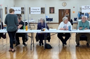 Election volunteers help voters check in and register at the Restoration Church polling center in Casper on Nov. 8, 2022. (Dustin Bleizeffer/WyoFile)