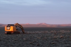 An excavator that had been digging up SouthPass-area sagebrush to remove a relic copper telecommunication line catches the morning sunlight on April 10, 2026. The digging was allegedly unauthorized and is the subject of a Bureau of Land Management investigation. (John Coffman)