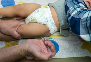 In this Jan. 29, 2015 photo, Dr. Charles Goodman vaccinates 1-year-old Cameron Fierro against hepatitis A after administering a measles-mumps-rubella vaccine at his practice in Northridge, California. (AP Photo/Damian Dovarganes)