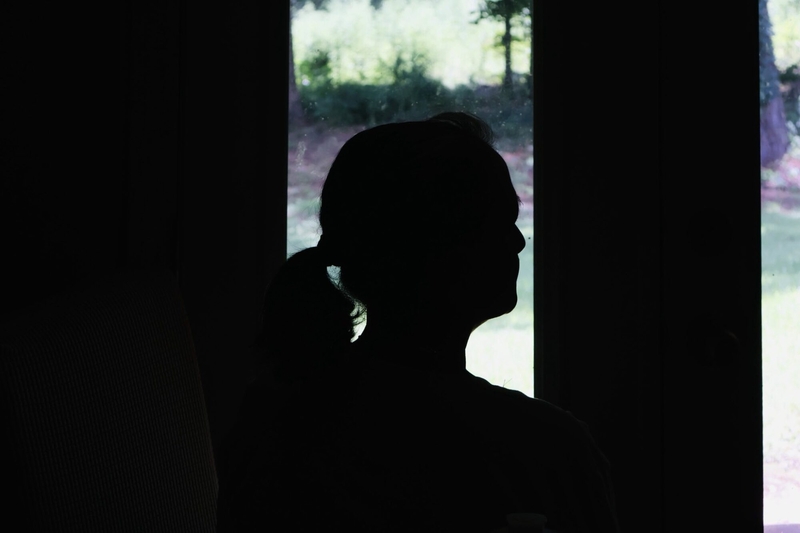 Idalia, a Koch Foods worker, looks outside a window in her daughter's home in Forest, Miss. She emigrated from Mexico to Mississippi in 2001 and obtained a green card 12 years later. She has been working in the poultry industry on and off for 20 years. Credit: Mukta Joshi/Mississippi Today