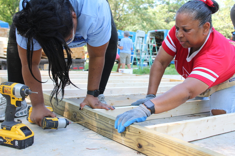 Teresa Buck, left, and volunteers from Delta Sigma Theta, Inc. began construction on Buck's home on Saturday, August 9, 2025. Buck said building her first home through Habitat for Humanity Mississippi Capital Area has given her the opportunity to be an independent homeowner. Credit: Maya Miller/Mississippi Today