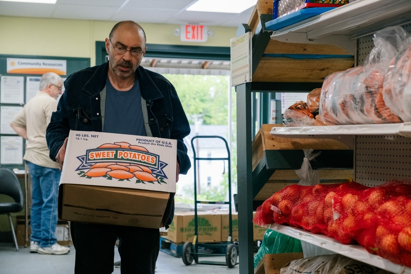 Emil Danailov, a volunteer and customer of the Plymouth Community Food Pantry, stocks the pantry shelves. CREDIT: SHAHRZAD RASEKH / CT MIRROR