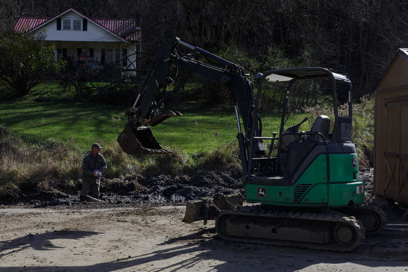 a large tractor scoops mud from a damaged site