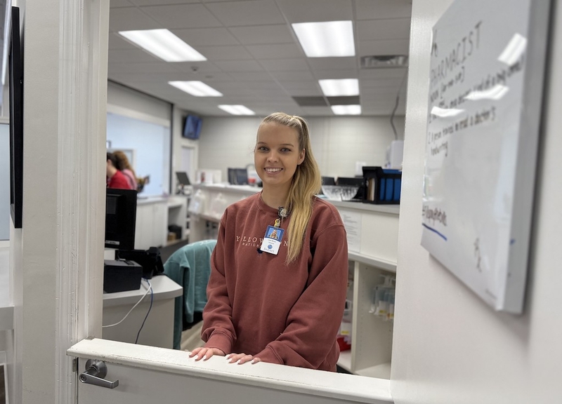 A woman stands at a pharmacy.