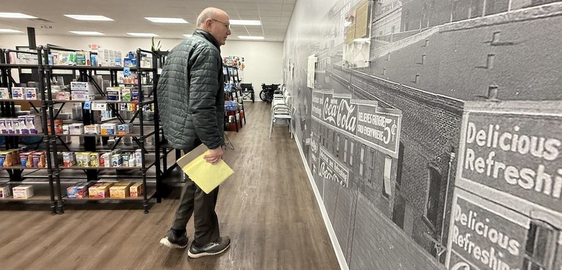 A man walks through a pharmacy.