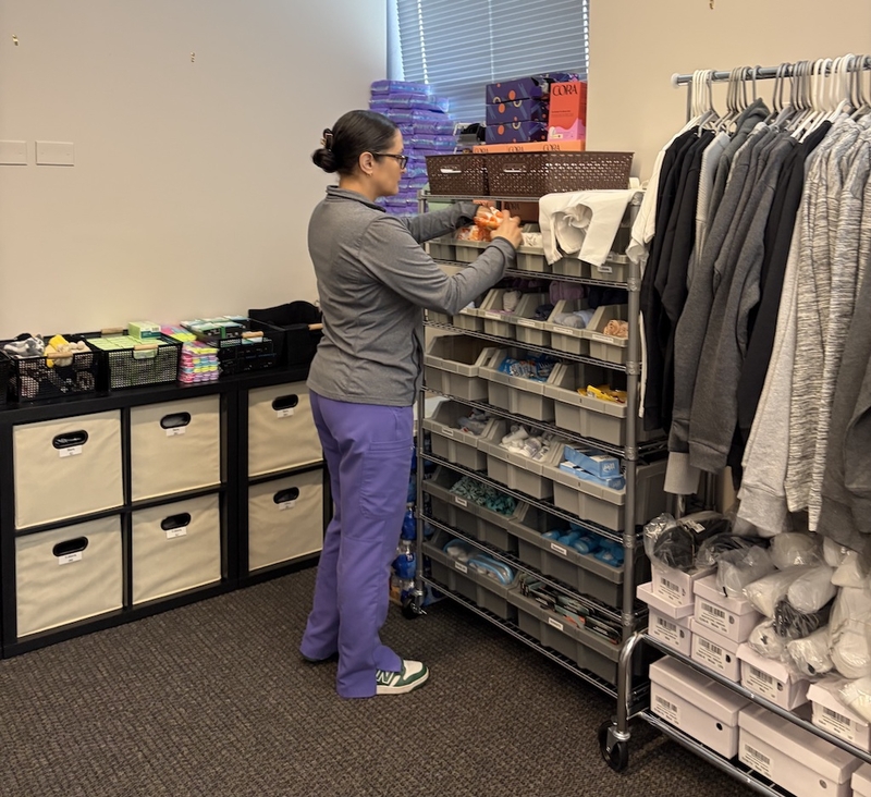 A staff member at Family Planning Associates in Chicago gathers supplies from a room in the clinic stocked with toiletries, basic clothing, shoes and other items for patient care packages. (Photo courtesy of Dr. Allison Cowett)