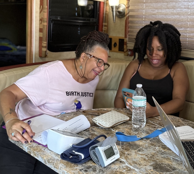 Midwife Sheila Simms Watson, left, talks with Isis Daaga during a pregnancy checkup at the Southern Birth Justice Network’s mobile midwifery clinic in Miami on March 21. (Photo by Nada Hassanein/Stateline)
