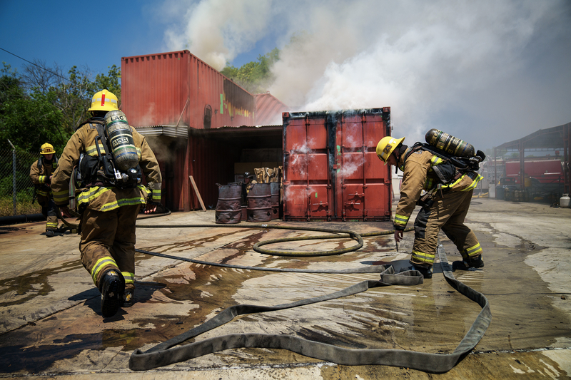 Firefighters work to put out a fire in shipping containers during a training session.