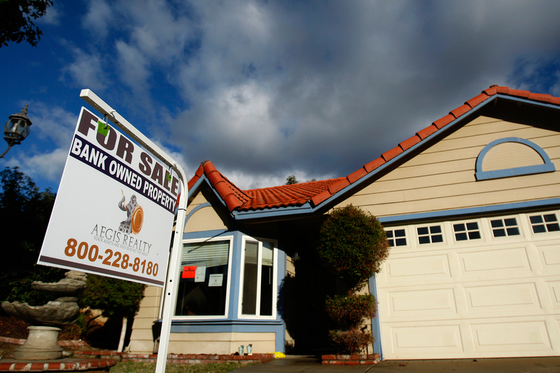 A sign that reads "For Sale Bank Owned Property" in front of a beige and blue foreclosed single-family home in Corona during the Great Recession. Dec. 18, 2008. Photo by Lucy Nicholson, Reuters