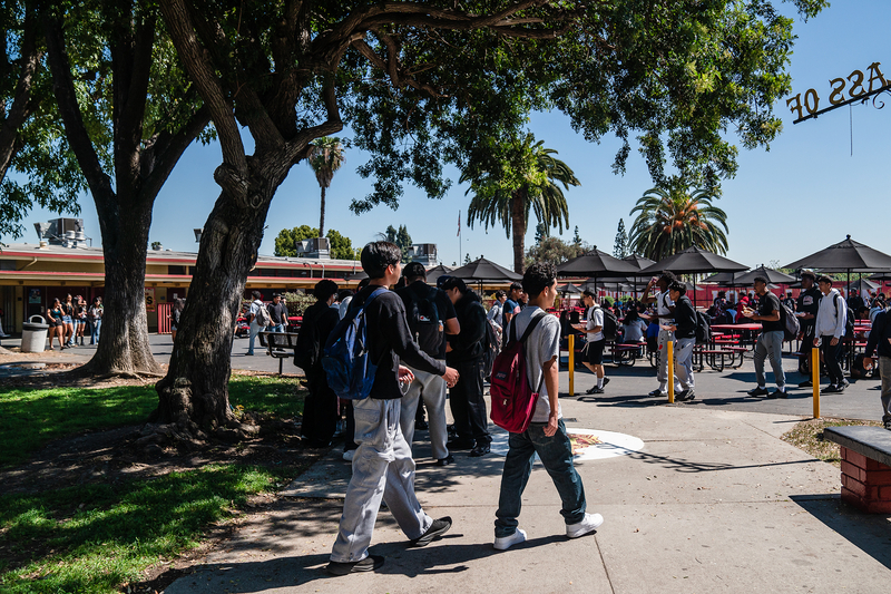 A wide view of high school students walking in the courtyard area of a high school.