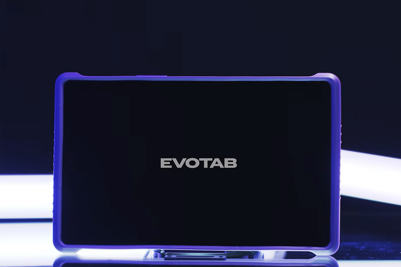 A tablet device labeled “EVOTAB” sits centered against a dark background, its screen black and framed by a glowing purple edge. The device rests on a small stand, illuminated by cool, directional lighting that creates a sleek, high-tech look with reflections on the surface below.