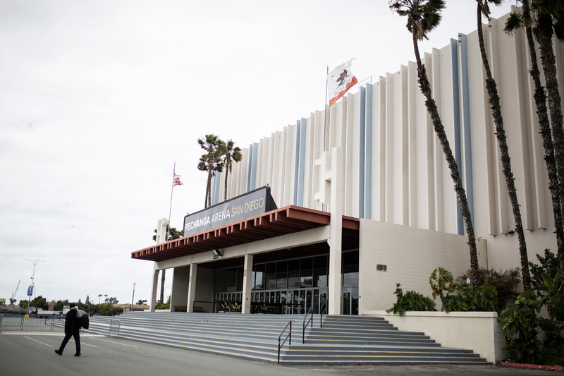 The entrance to Pechanga Arena in San Diego, with palm trees and a person walking across the mostly empty plaza.
