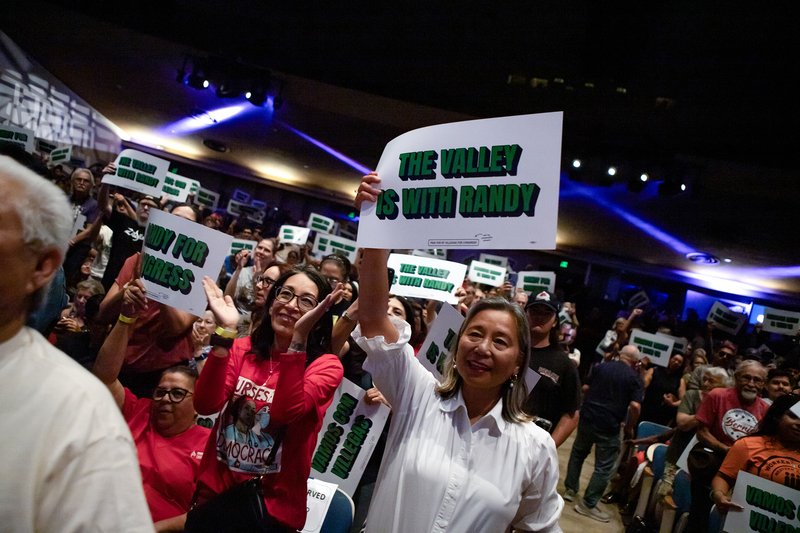 Supporters cheer and hold green-and-white campaign signs at a crowded political rally, including one reading, “The Valley is with Randy.”