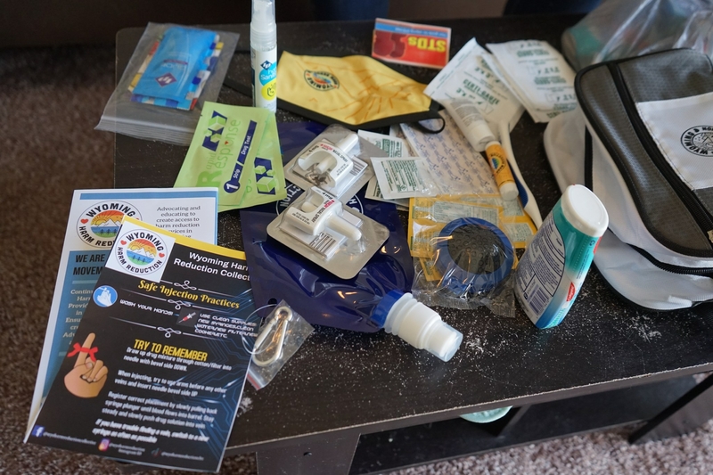 A pile of harm reduction tools, including naloxone nasal spray, fentanyl test strips and informational brochures